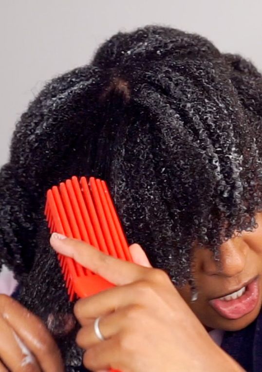 someone detangling her hair with force