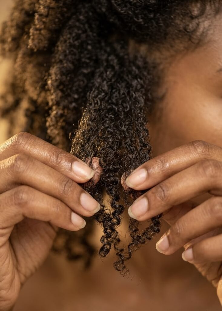 someone detangling hair to start her 4C hair wash day routine