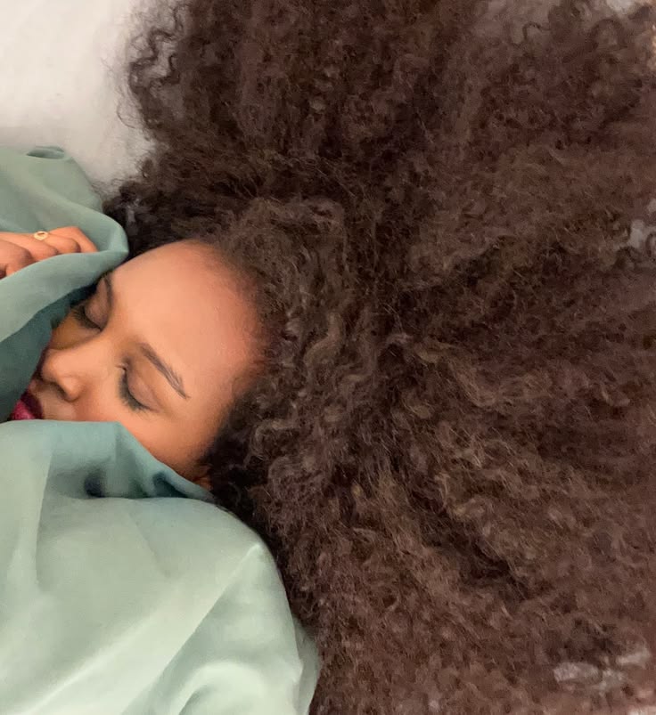a girl with afro hair sleeping