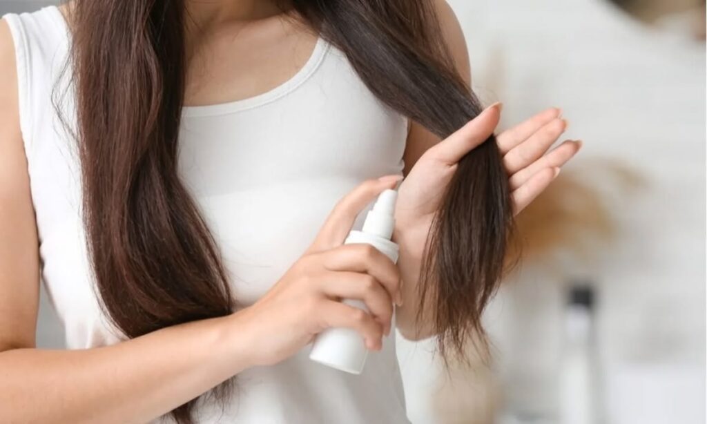 someone applying hair spray to the hair