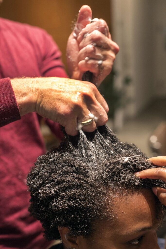 someone applying hair butter to hair