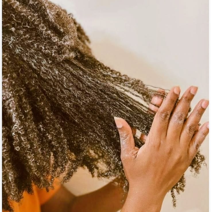 someone applying leave-in products to her hair