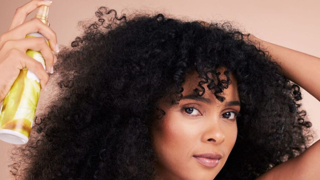 someone applying a product that protects hair from heat