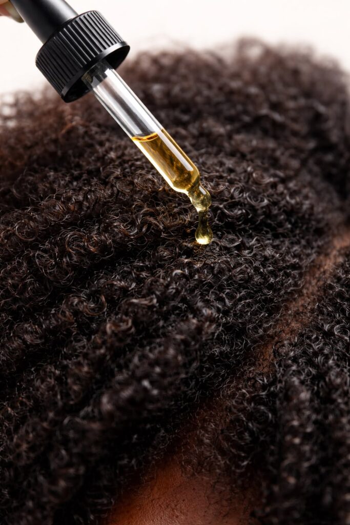 someone moisturizing her hair with oil
