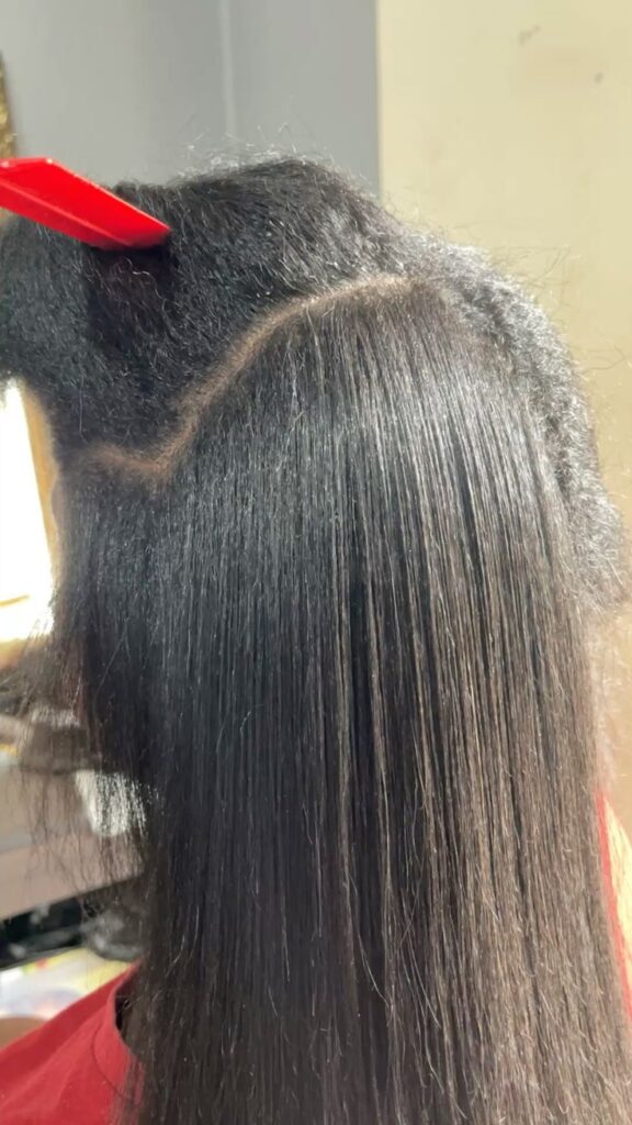someone flat ironing her hair