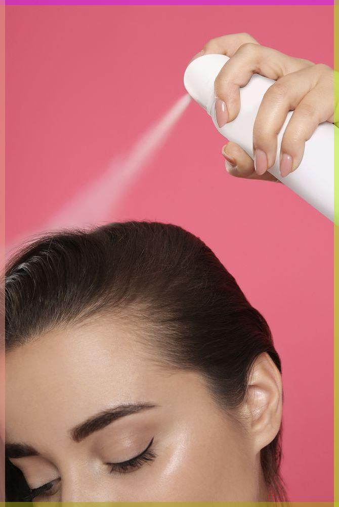 someone applying dry shampoo to her hair