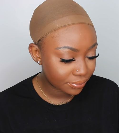 someone wearing wig cap about to wear wig over natural hair