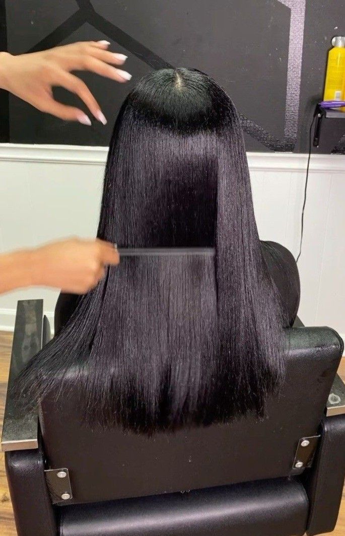 someone getting her hair flat ironed