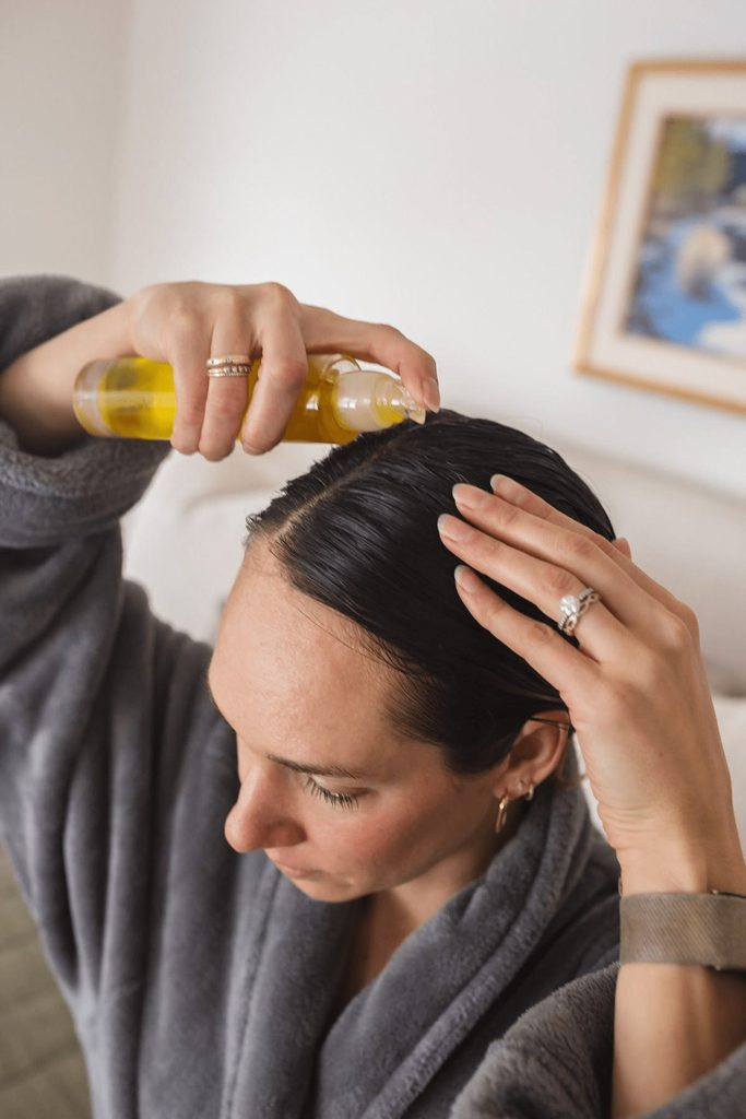 someone applying DIY hot oil treatments to her scalp