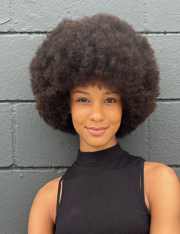 someone with full afro in her afro hair journey