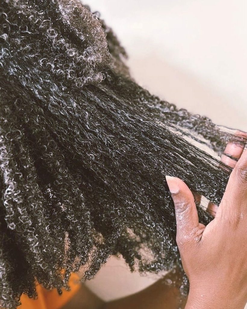 someone that is detangling hair with finger  as part of healthy hir routine ideas