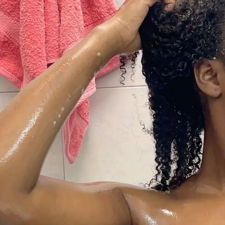 someone washing hair with conditioner