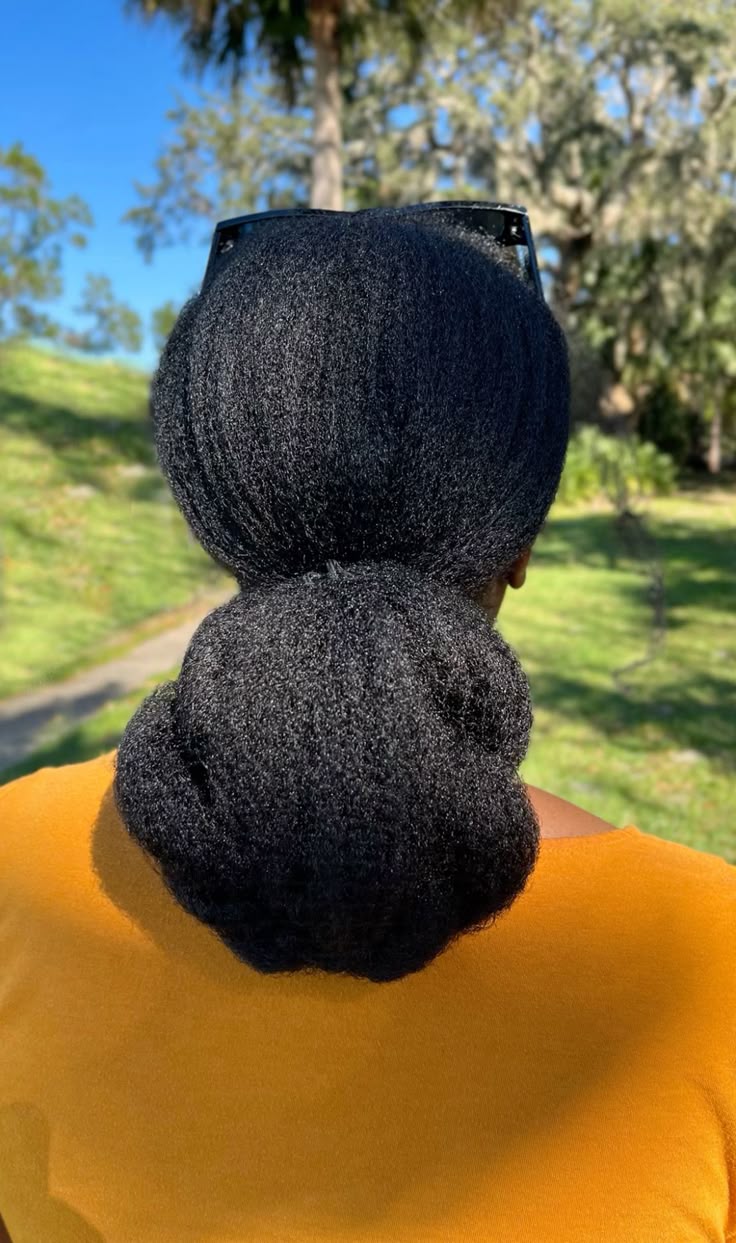 someone with low bun afro hairstyle