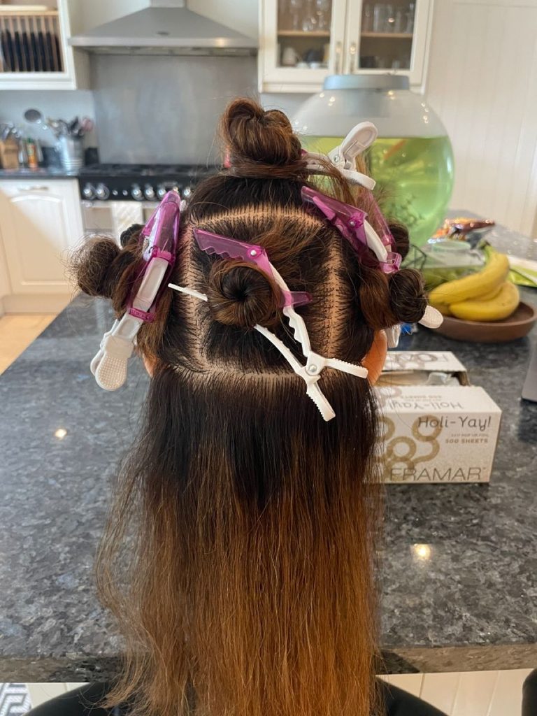 someone with six sectioned hair as part of wash day setups for natural hair