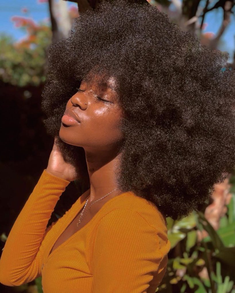 someone showing off her afro hair as a way to stop comparing your hair to influencers