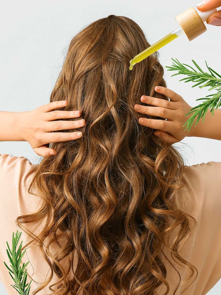 someone applying oil to her hair