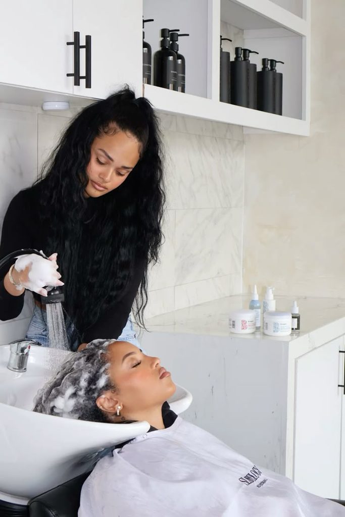 someone washing hair in a salon